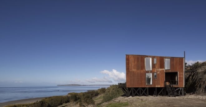 side view of red zinc-clad building by the sea