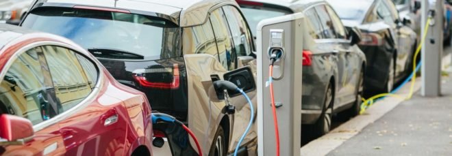 two electric cars plugged into a charging station