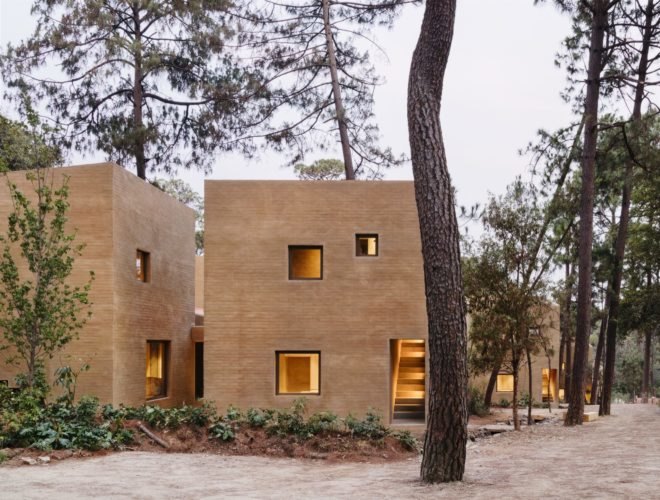 several block-like buildings made from light pink earth brick