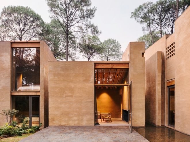 light pink brick homes with open glass doors to an outdoor courtyard space
