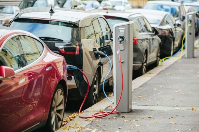 two electric cars plugged into a charging station