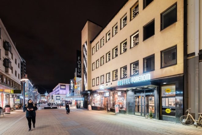 hostel's tan exterior lit up at night
