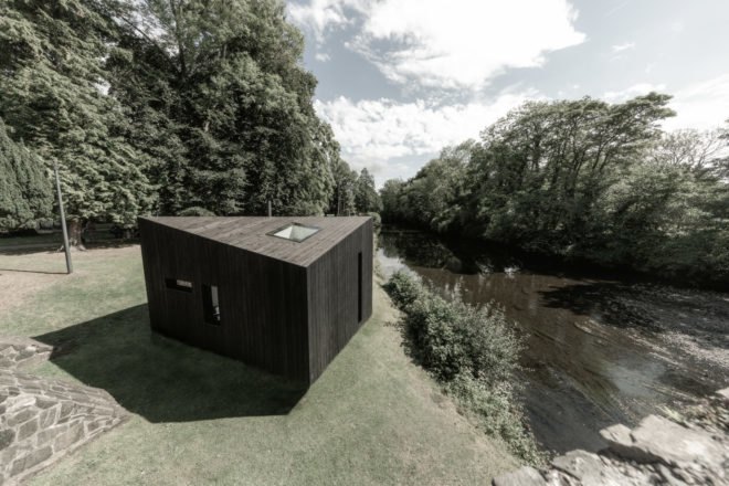 black cabin with sloped roof and skylight