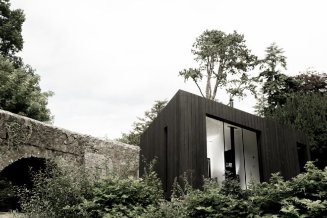 black cabin with large glass window