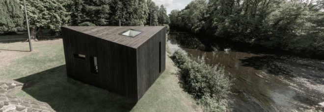black cabin with sloped roof and skylight