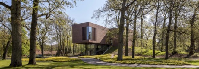 museum with glass walls on bottom floor and brick exterior on top floor