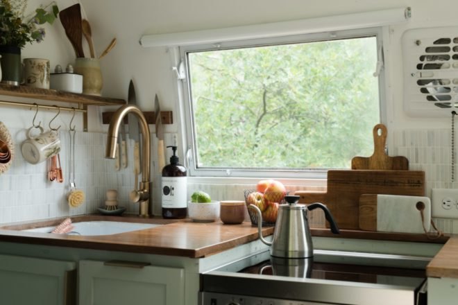 kitchen with sink and stove top on light green cabinets