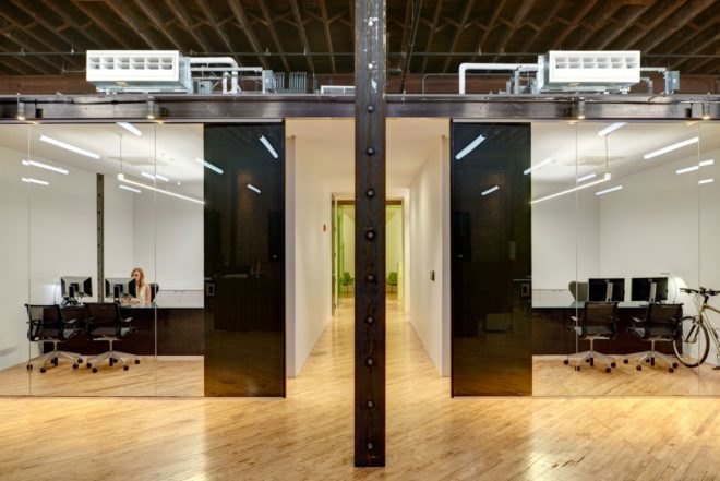 office spaces with black desks and glass walls