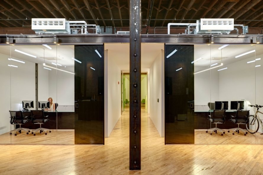 office spaces with black desks and glass walls