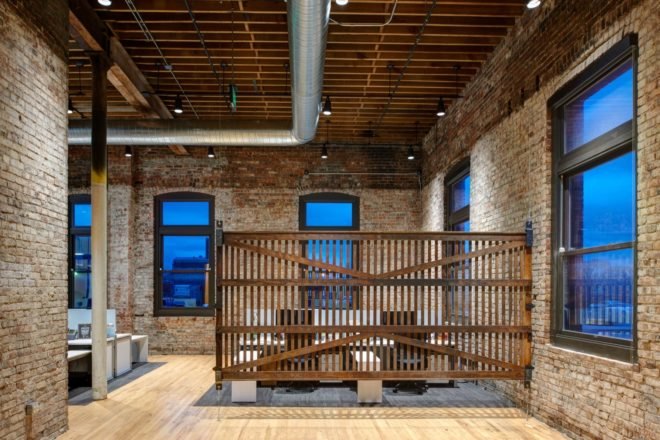 office space with brick walls and a slatted wood divider
