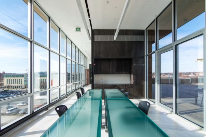 light filled meeting room with translucent tables and black office chairs