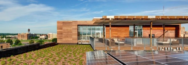 patio area topped with green roof and beside solar panels