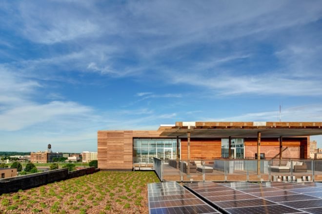 patio area topped with green roof and beside solar panels