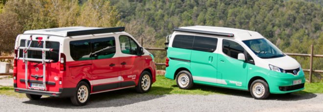 a red camper parked next to a light green camper