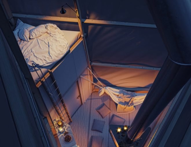 a triangular interior space with an elevated sleeping platform at night