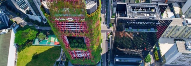 aerial view of tower with red mesh cladding and greenery