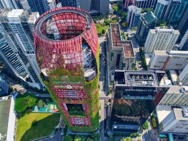 aerial view of tower with red mesh cladding and greenery