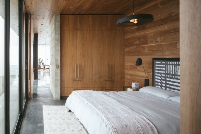 bedroom with white bed and tall wardrobe in wall