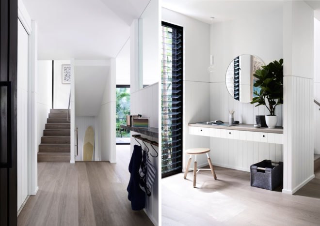 On the left, entry way with small wall hooks and a staircase. On the right, small desk built into a wall nook