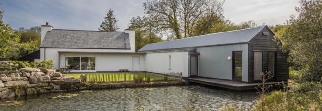 White cottage overlooking a pond