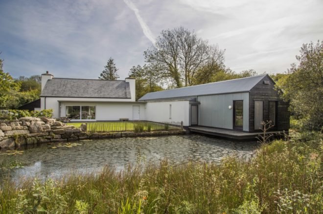 White cottage overlooking a pond