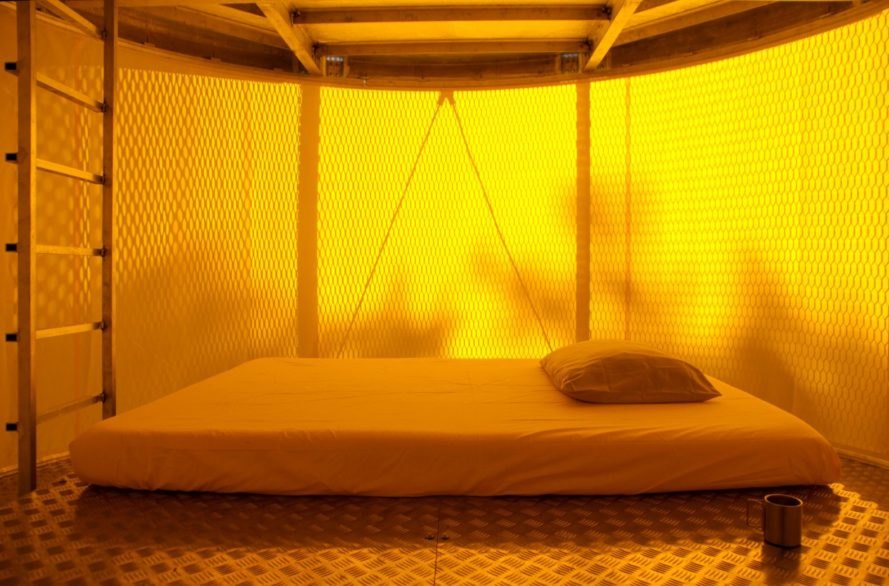 yellow-hued interior with bed on the floor