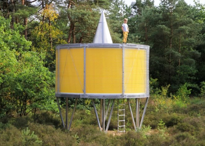 child on top of round yellow pavilion on metal supports