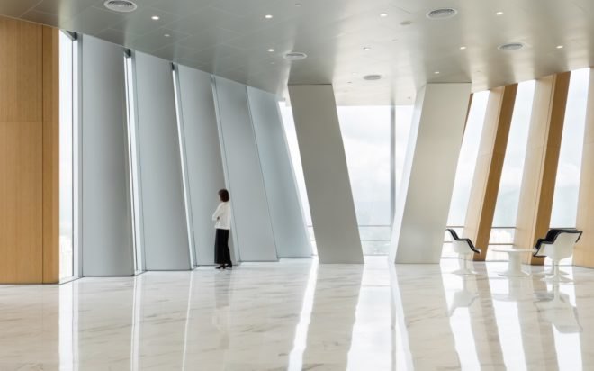 person looking out full-height windows