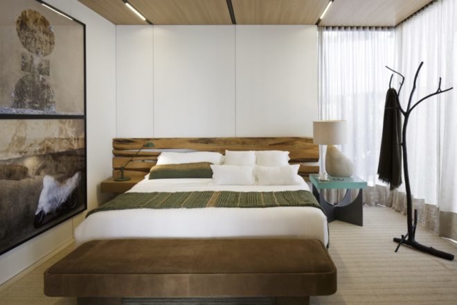 Bright bedroom with wood headboard and tree-like coat hanger