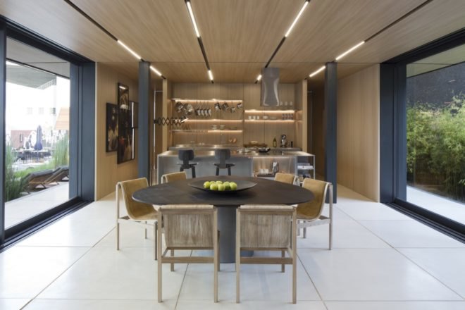 open plan dining and kitchen paneled in light wood