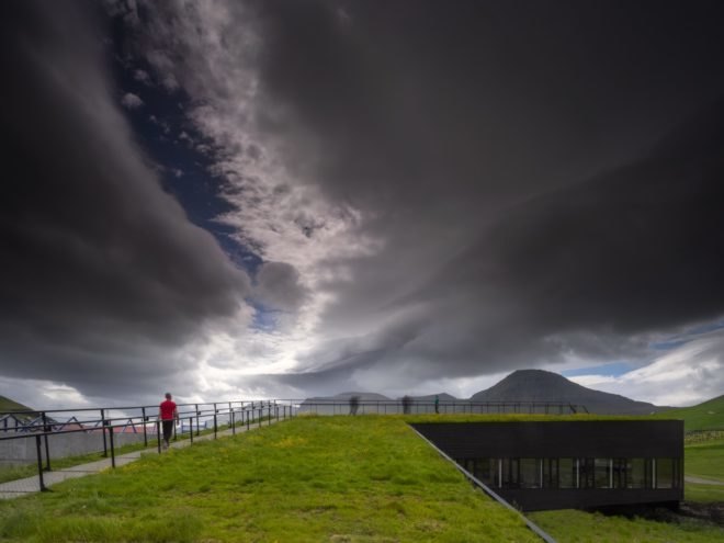green roofed building under stormy skies