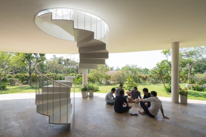spiral staircase with people sitting on open-air deck nearby
