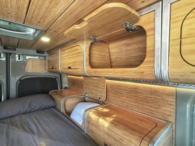 wooden paneled interior and storage cabinets beside the bed