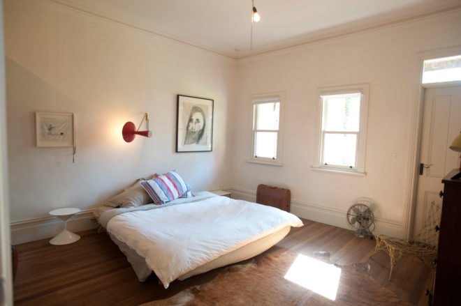 brightly lit bedroom with large white bed