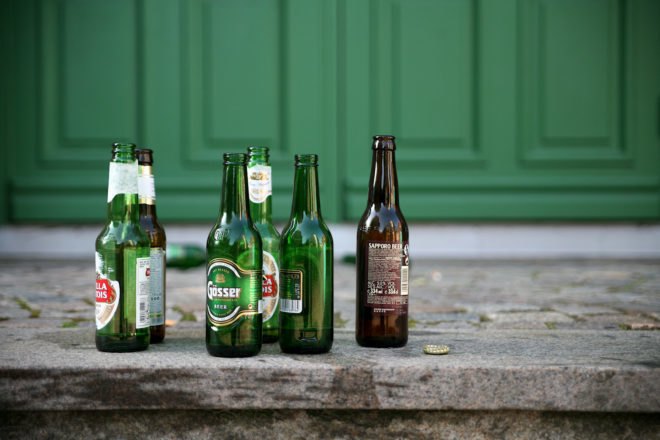 several glass beer bottles on a sidewalk