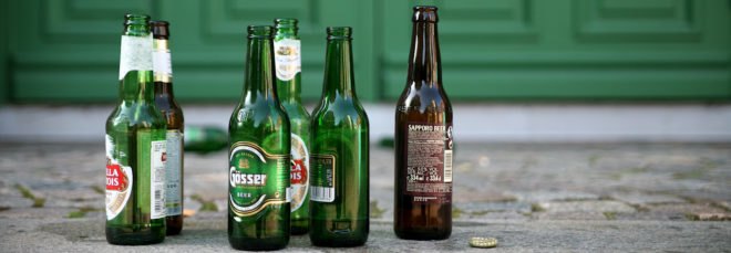 several glass beer bottles on a sidewalk