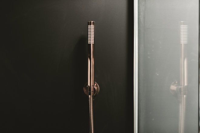 a sleek, narrow, copper shower head