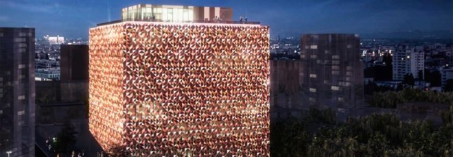 tall cube building with a reddish sparkling exterior at night