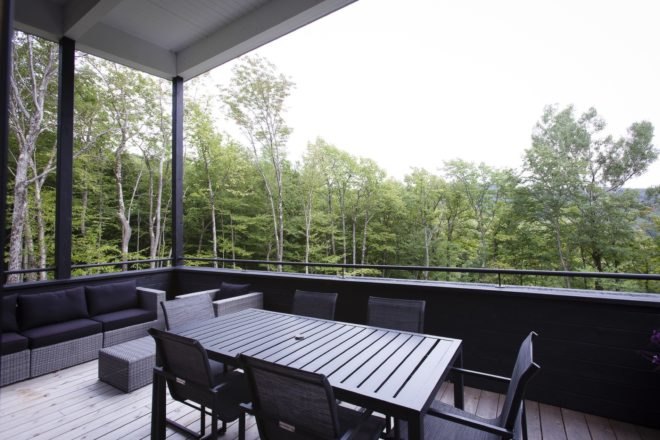 covered outdoor patio with black patio table and gray and purple couch