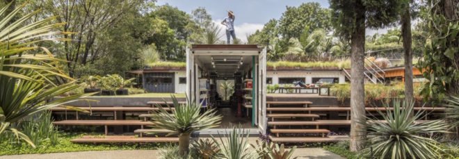 person standing on a green roof atop a white shipping container