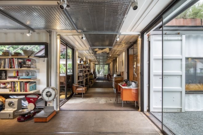 art and books on shelves inside a shipping container