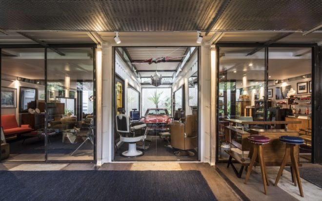 shipping containers with glass walls revealing old cars and vintage knick knacks and furniture