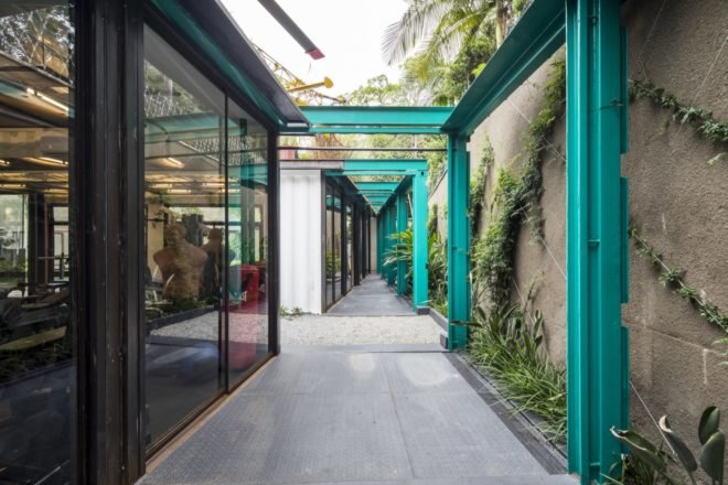 exterior walkway lines with plants and bright blue metal poles