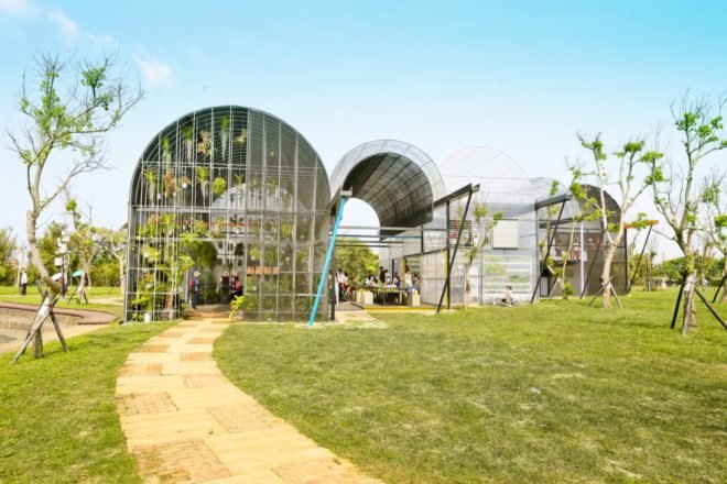 greenhouses with rounded roofs on a grassy lot