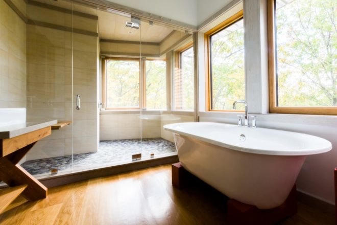 bathroom with free standing tub and large shower space with glass wall