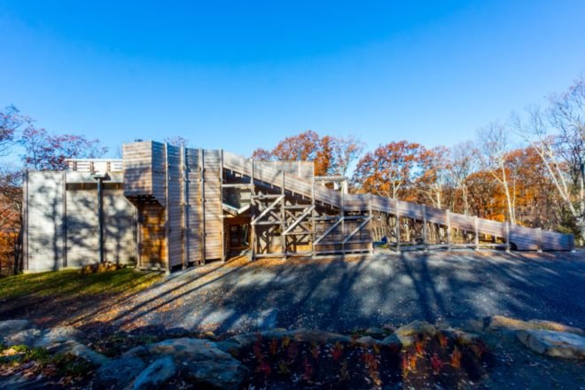 side view of sloping timber home with long ramp walkway