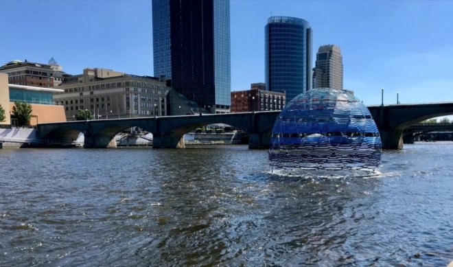 blue dome floating on a river with skyscrapers in background