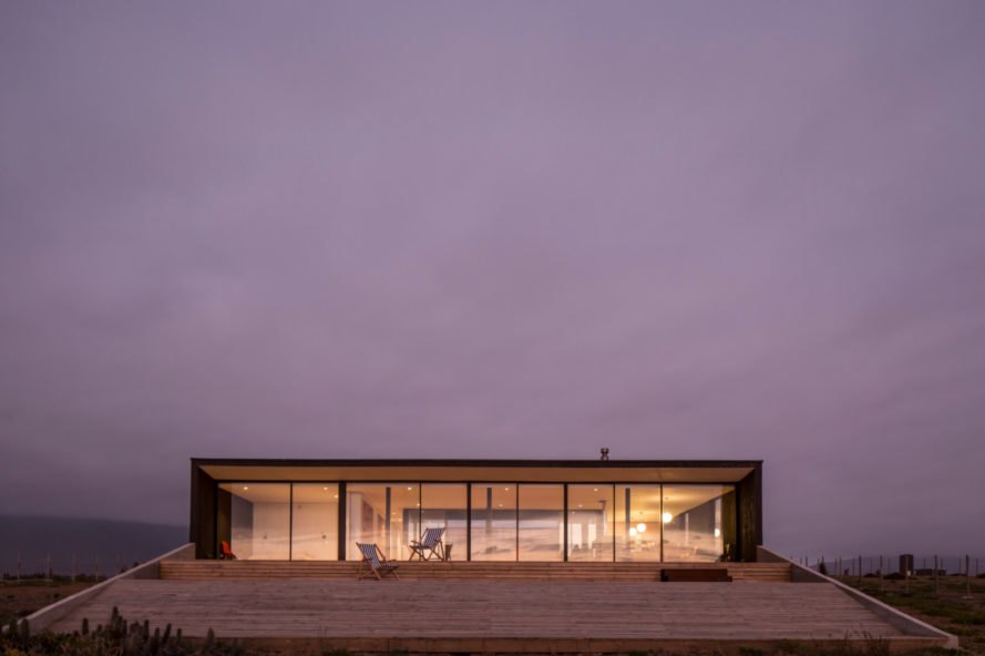 evening view of horizontal home with glass facade