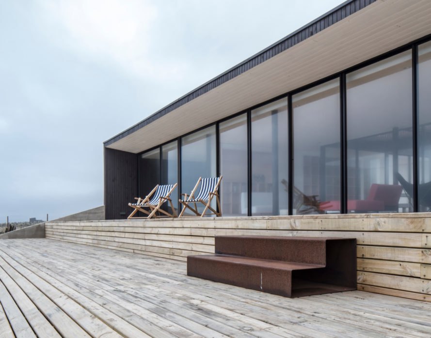 a home with a glazed facade leading to a patio