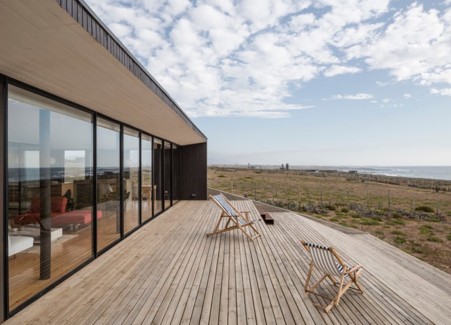 a home with a glazed facade leading to a patio